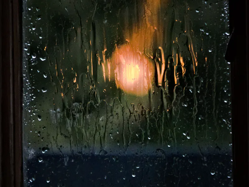 Rain streaming down a window at night