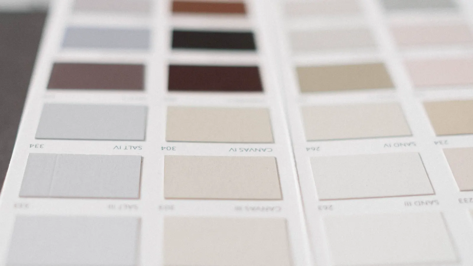 A close view of a printed sheet of paint swatches in whites, creams, beiges and browns