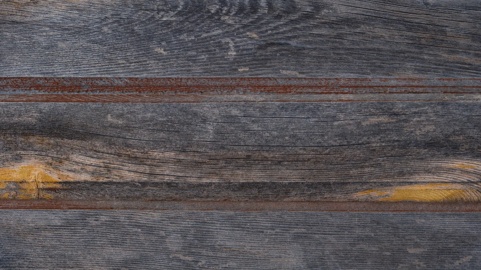 Bare horizontal wood boards weathered gray, with raised grain, checks and a few knots