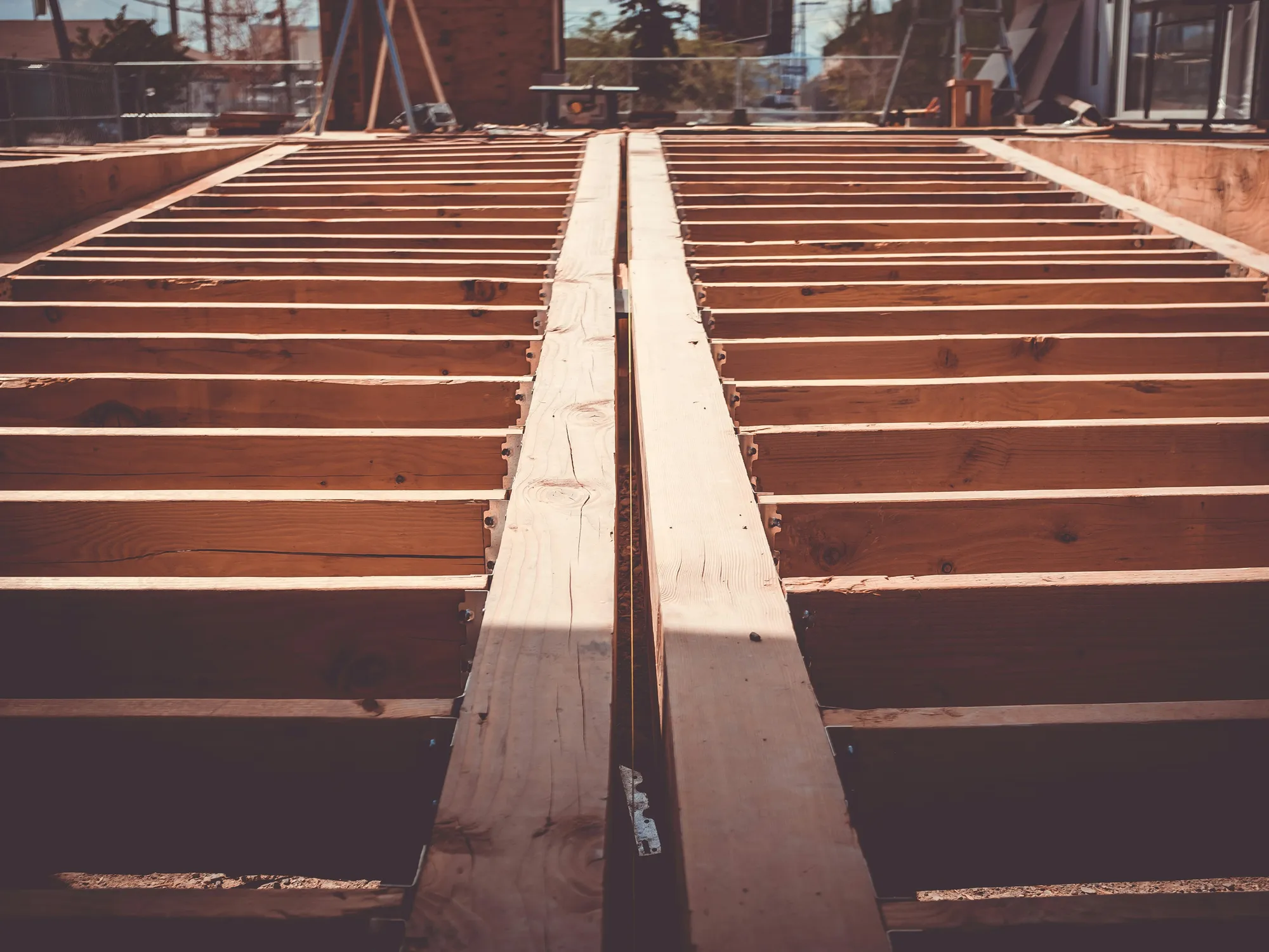 Rows of new deck joists on either side of a doubled center beam