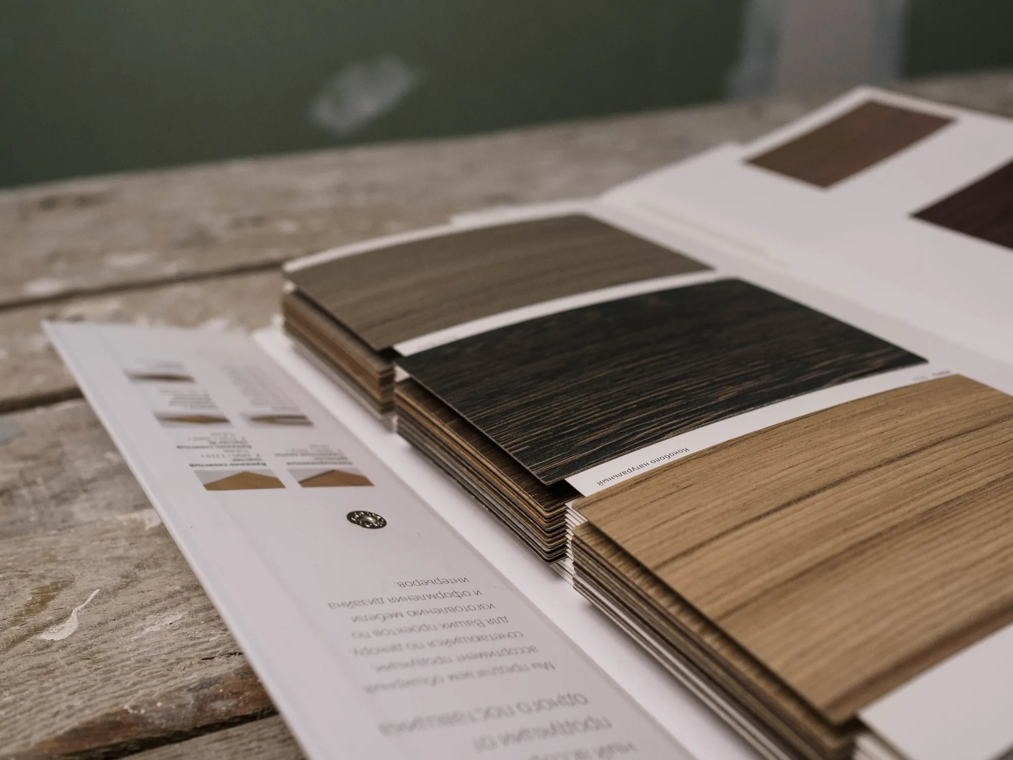 A fan of wood sample swatches in different tones laid open on a weathered table